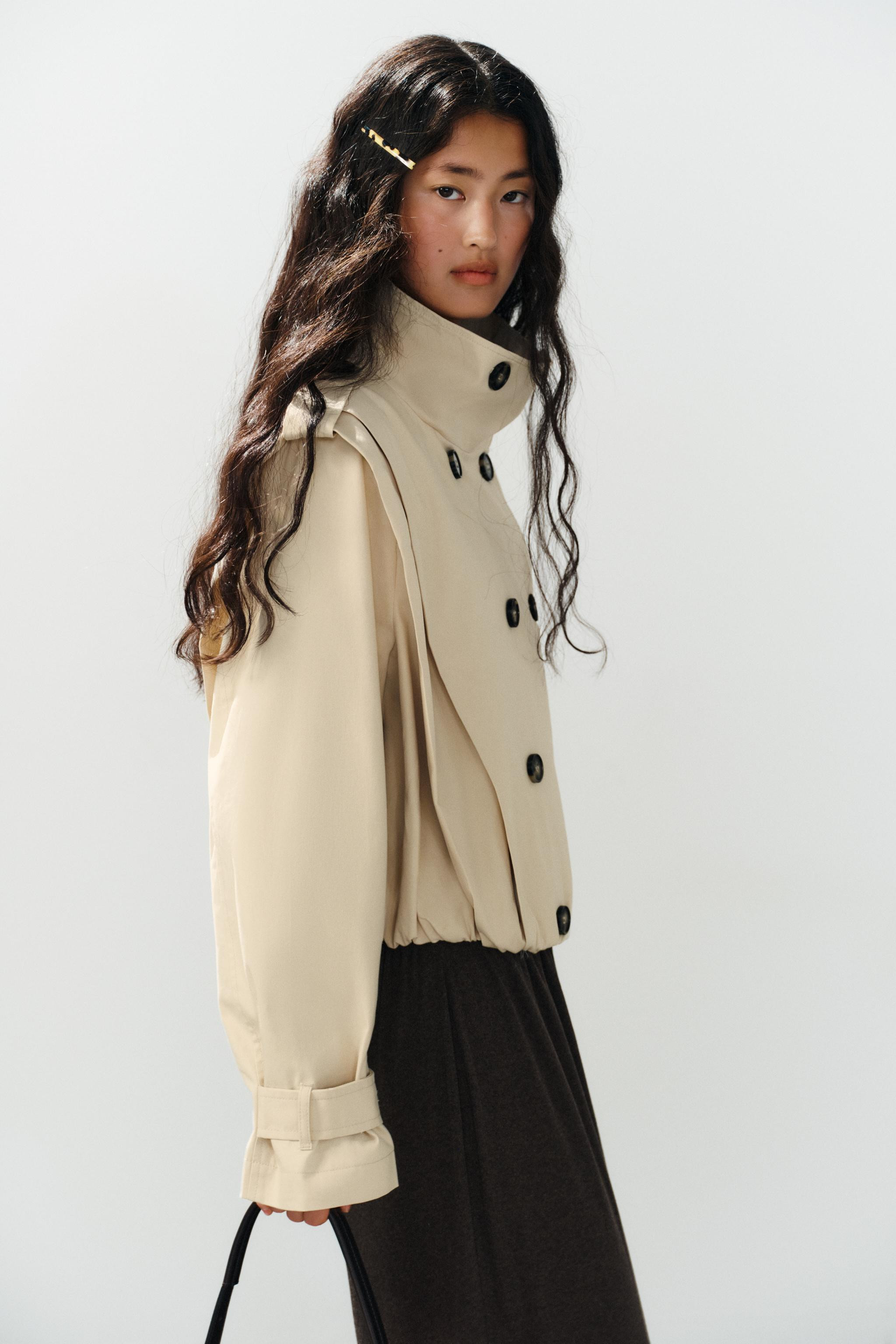 Model height: 173 cmShort trench coat featuring a high neck and long sleeves with tabs. Pleat det... | Zara UK