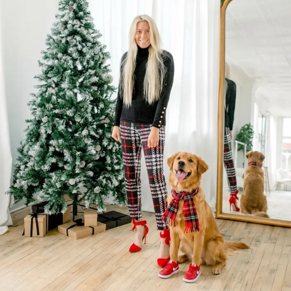 A bright, modern holiday studio with soft natural light pouring through sheer white curtains. A tall flocked Christmas tree stands to the left, surrounded by neatly wrapped neutral-toned gifts tied with black ribbon. In the center, a stylish woman with long blonde hair wears a fitted black turtleneck with gold button accents and festive red-and-black plaid pants. Her red bow heels add a playful, elegant pop of color. Sitting proudly beside her is a golden retriever dressed to match—wearing a cozy red plaid scarf and tiny red sneakers, creating an adorable coordinated holiday moment. Behind them, a full-length gold mirror reflects the scene, adding depth and warmth to the festive aesthetic. The overall vibe is cheerful, polished, and Pinterest-perfect holiday magic.

⸻

Hashtags

#holidayphotoshoot #christmasstyle #festivefashion #matchingoutfits #dogmomlife #goldenretrieverlove #holidayaesthetic #plaidseason #christmasvibes #winterstyle #pinterestinspired #styledshoot #holidaymagic #trendychristmas #ootdinspo #fashionandpets #holidayhome #joyfulmoments #redandplaid #christmascontent #cutedogpics #holidaycheer #festiveseason #studiochristmas #trendyheidi

#LTKGiftGuide #LTKHoliday #LTKdayinmylife