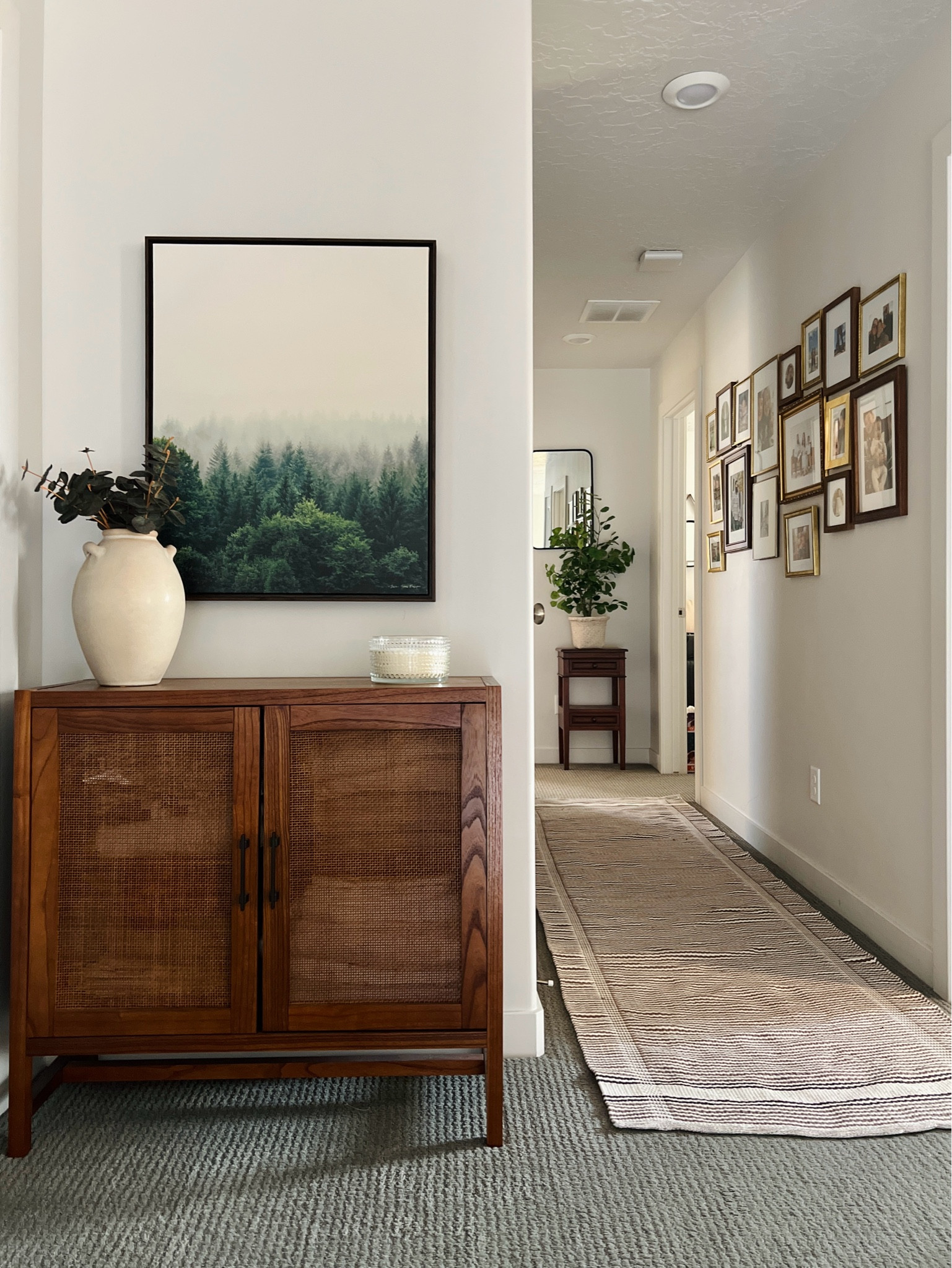 Gave our hallway an upgrade with a gallery wall and it transformed this whole space. 

Gallery wall frame collection 
Wooden side table
Gold frames
Wood frames
Wall art
Mirror
Runner rug
Tall vase
Faux small ficus tree

#LTKHome #LTKFindsUnder50 #LTKFindsUnder100