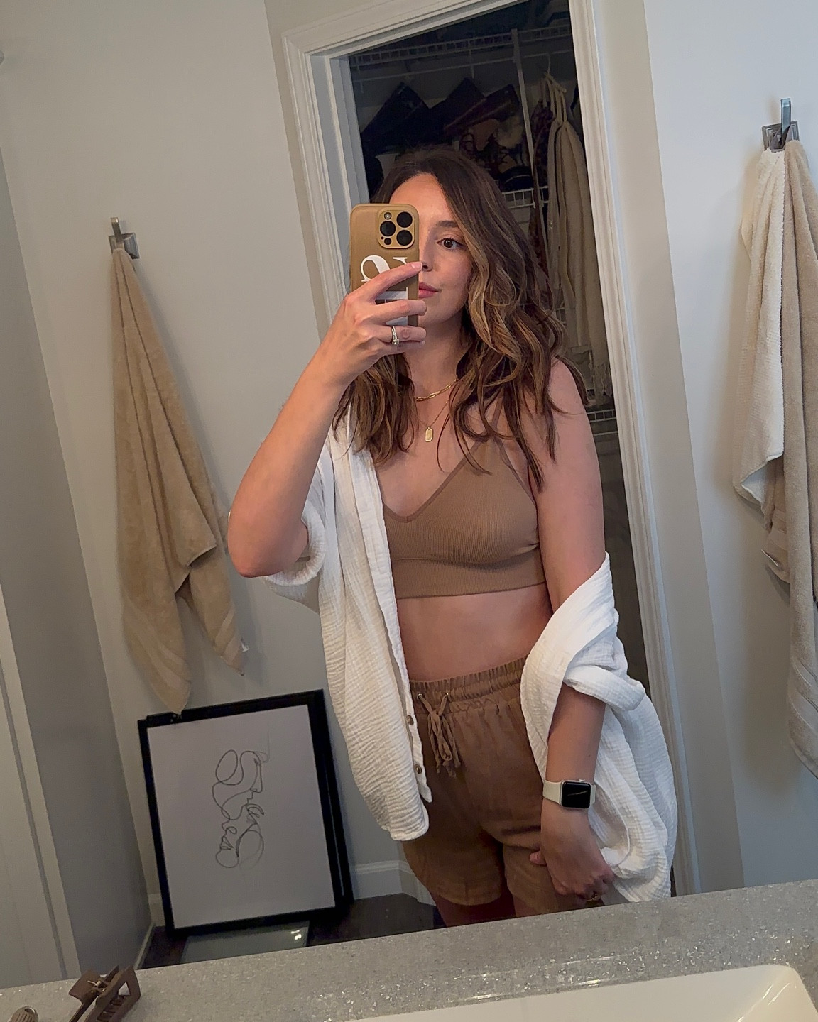 Womens casual summer outfit. White linen button up. Tan bralette. Tan dress shorts. Gold jewelry. Tan phone case. 

#LTKFind #LTKSeasonal #LTKstyletip