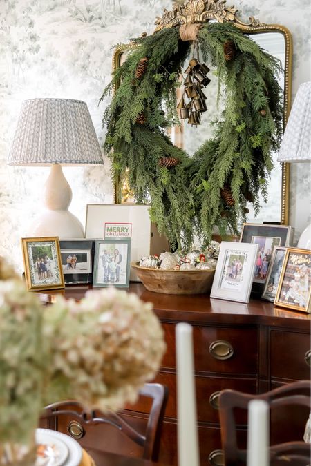 My dining room Christmas decor includes this lovely natural wreath with a cluster of bells hanging on the mirror over my buffet. Picture frames and a beautiful bowl of mercury glass ornaments sits underneath it.

#LTKHoliday #LTKSeasonal #LTKhome