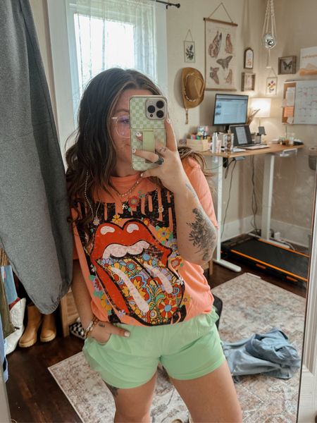Super casual comfy and super affordable Walmart outfit! $10 super Cute pink Rolling Stones graphic tee ultra soft wearing large for oversized fit. $12 shorts Neon green athletic shorts wearing large (runs small!) 