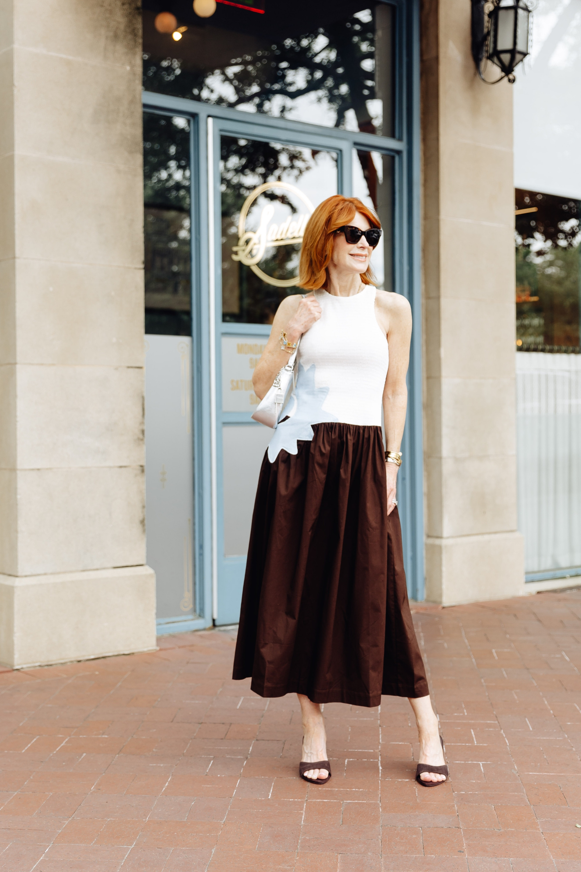 This dress does all the work — the smocked white top, full brown skirt, and soft blue detail make it feel special without needing much styling. Such a chic option for summer dresses, travel outfits, or dinner on vacation. #LTKootd

#LTKOver40 #SummerDresses #TravelOutfits #VacationStyle 

 #LTKootd #LTKSeasonal #LTKOver40