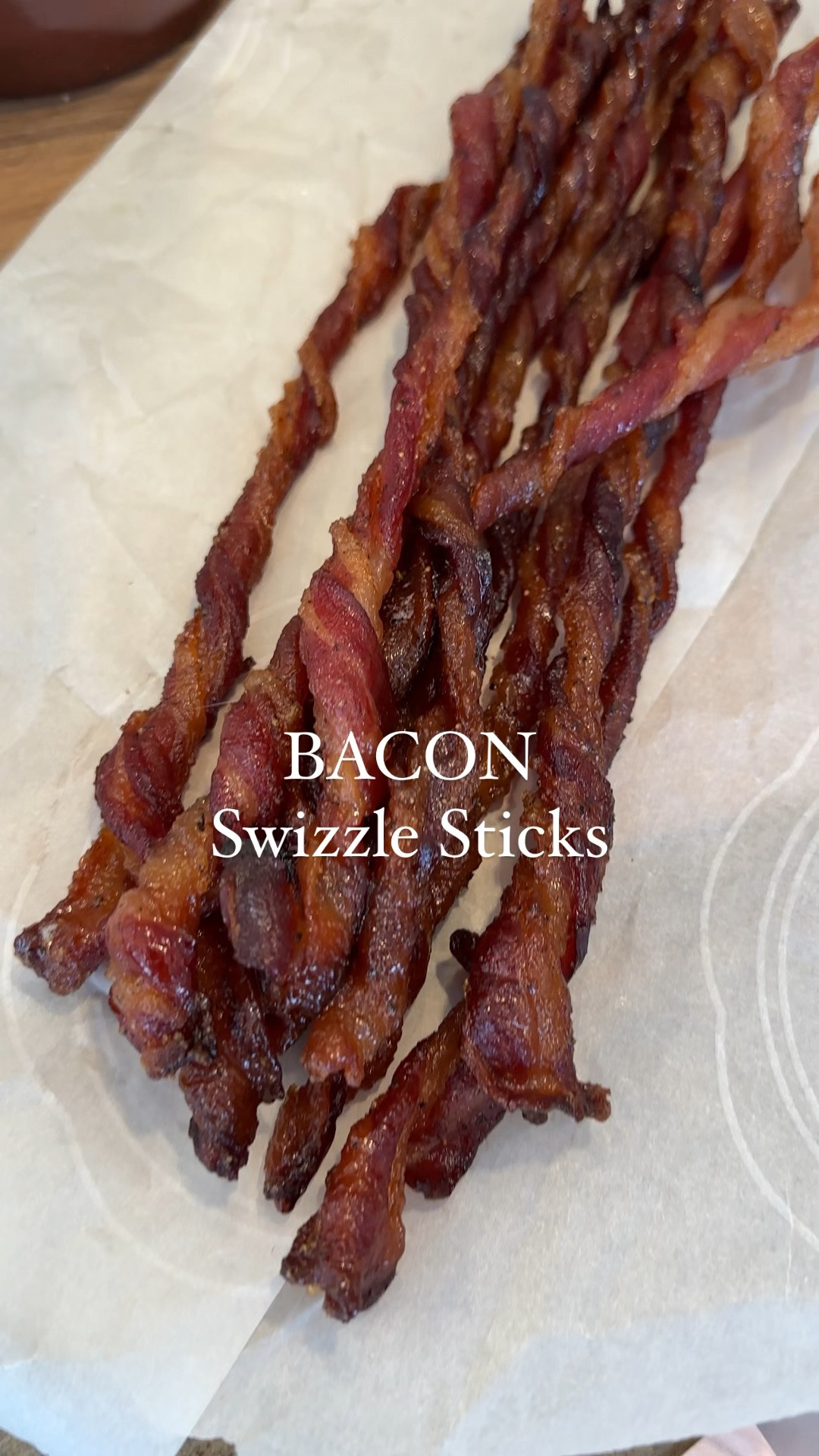 Bacon Swizzle Stick 
1 lb of bacon
1 cup dark brown sugar
Freshly cracked pepper

Baking sheet
Parchment paper
Baking rack

Add the bacon to a large bowl and separate.
Add the brown sugar, freshly cracked pepper and mix well ensuring to coat every side and piece of bacon.

Preheat the oven to 350°.
To a lined baking sheet, add a baking rack on top of the parchment paper. (Very important step for clean up).
Twirl one end of the bacon until the entire piece is twirled.
Lay across the sheet pan length wise. Repeat until entire package is on pan. They can be nested closely together, as they will shrink.
Add to preheated, middle rack in the oven and check every 10 minutes, until about the 25-30 mark.

The melted sugar may smoke, keep a window open, if possible, or halfway through change out parchment paper to avoid brining the fallen sugar.

Let fully cool to set, about 15 minutes.
Eat as is or add to a Bloody Mary as a delicious garnish!
Store in the fridge.