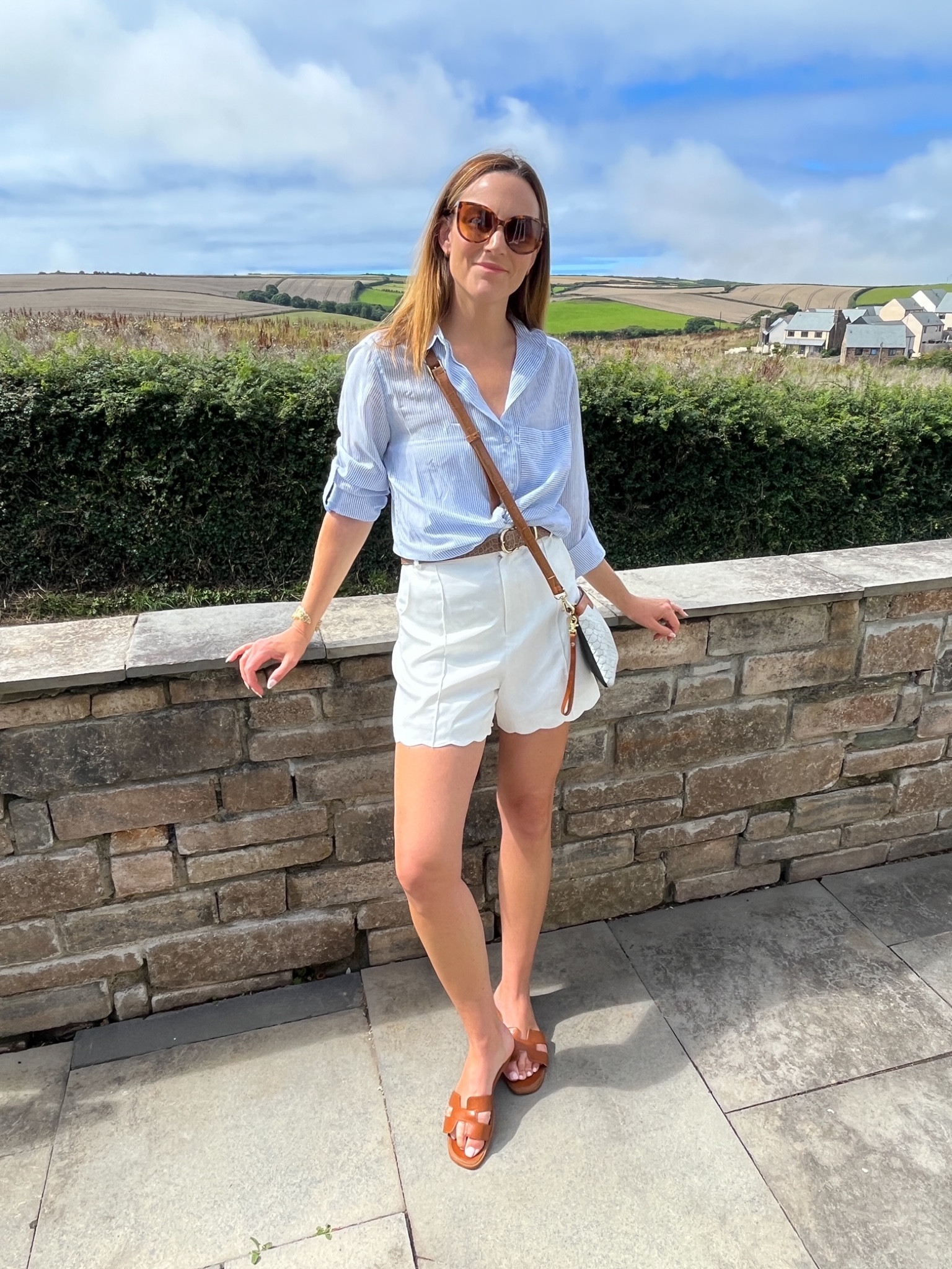 Blue stripe shirt, tan belt, white shorts, tan slides, brown and white crossbody hag, sunglasses

#LTKeurope #LTKstyletip #LTKSeasonal